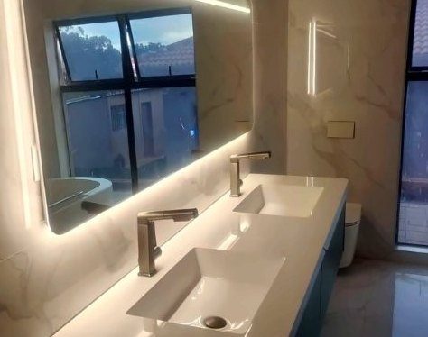 Bathroom with double basin and backlit mirror