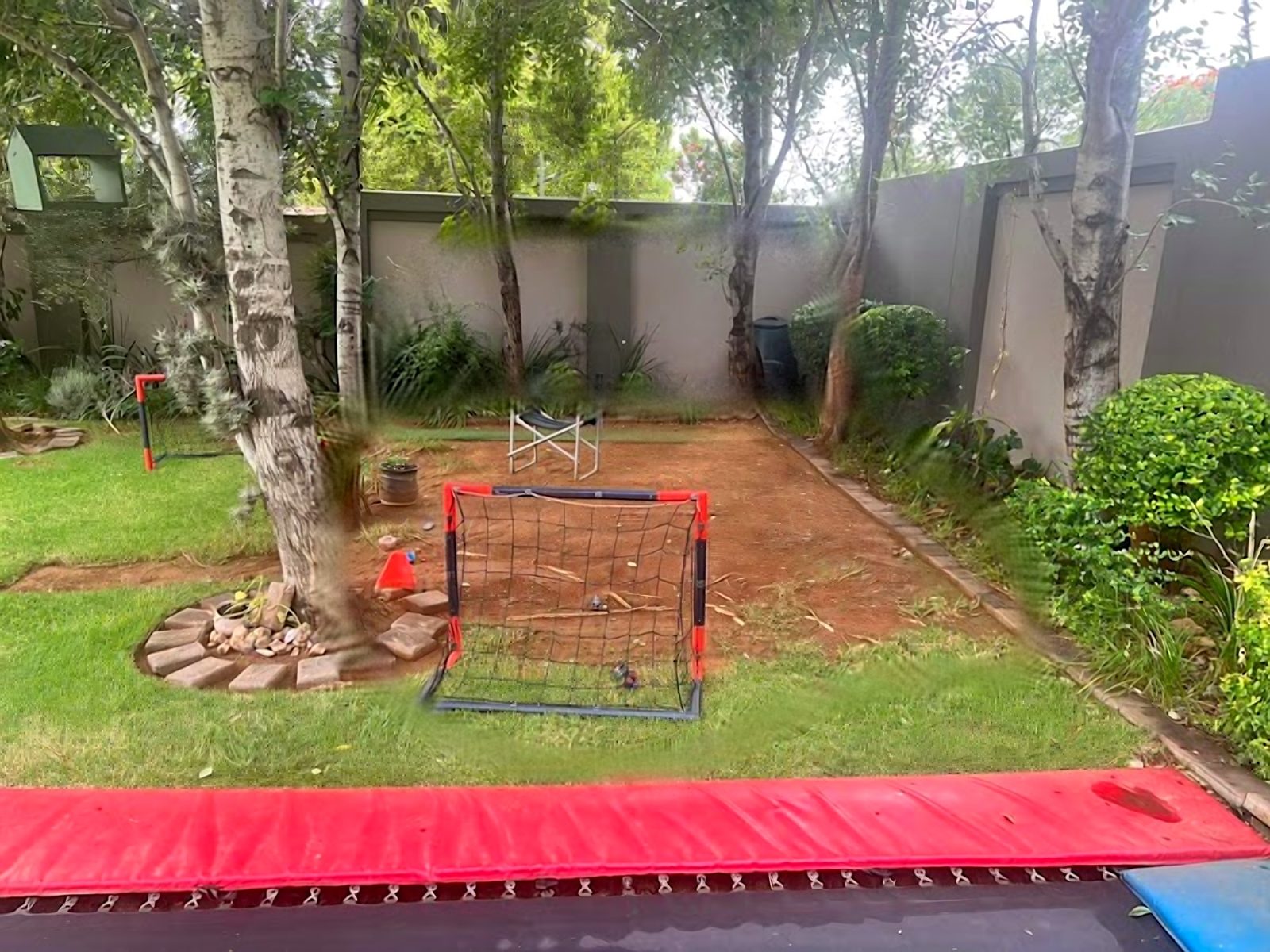 Garden before: bare soil patch with a play goal